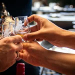 Hands clinking whiskey glasses at a private event space in Las Vegas at 1923 Prohibition Bar