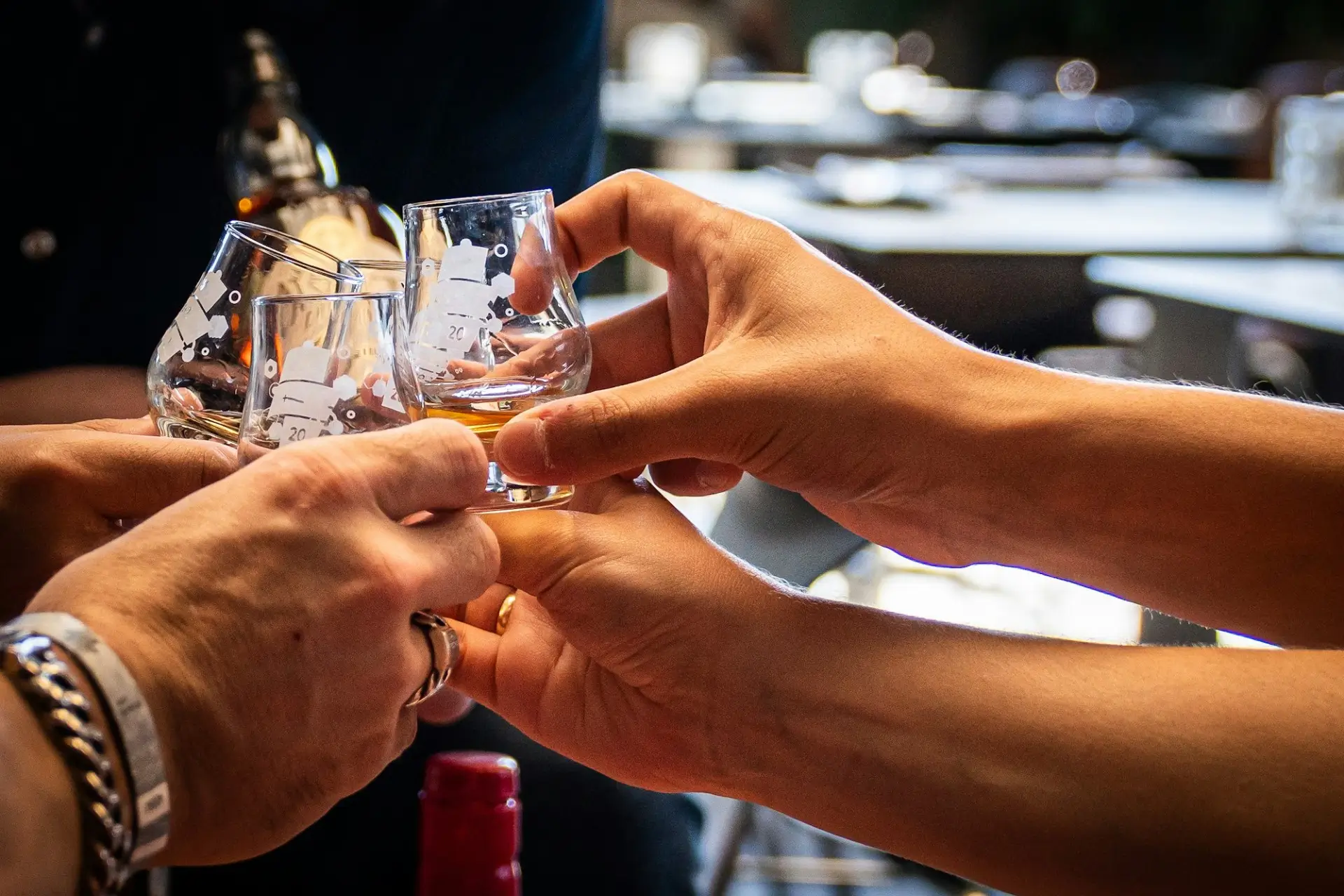Hands clinking whiskey glasses at a private event space in Las Vegas at 1923 Prohibition Bar