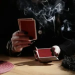 A close-up of a magician shuffling red playing cards during the Ghost Stories show at 1923 Prohibition Bar, widely named one of the best bars in Las Vegas for real Vegas horror stories.